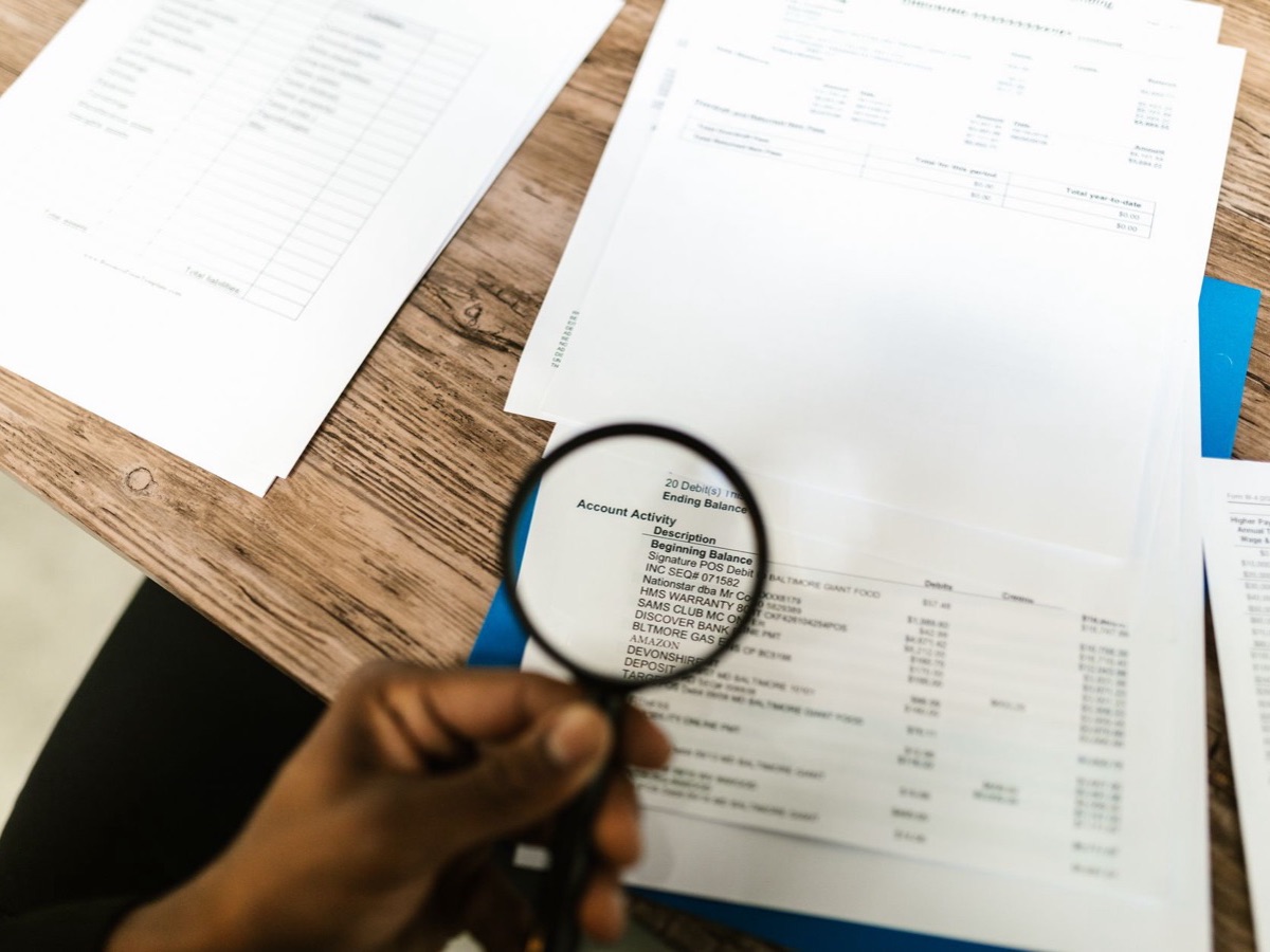 Loupe examinant des documents, image de l'audit sémantique qui hiérarchise les priorités