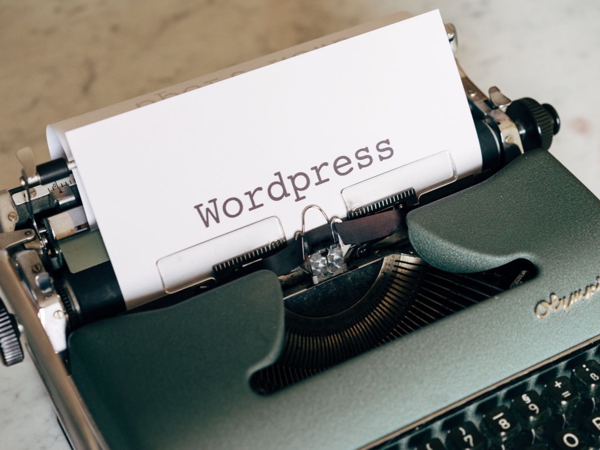 Machine à écrire vintage tapant le mot Wordpress, symbole d'un CMS propre et bien référencé