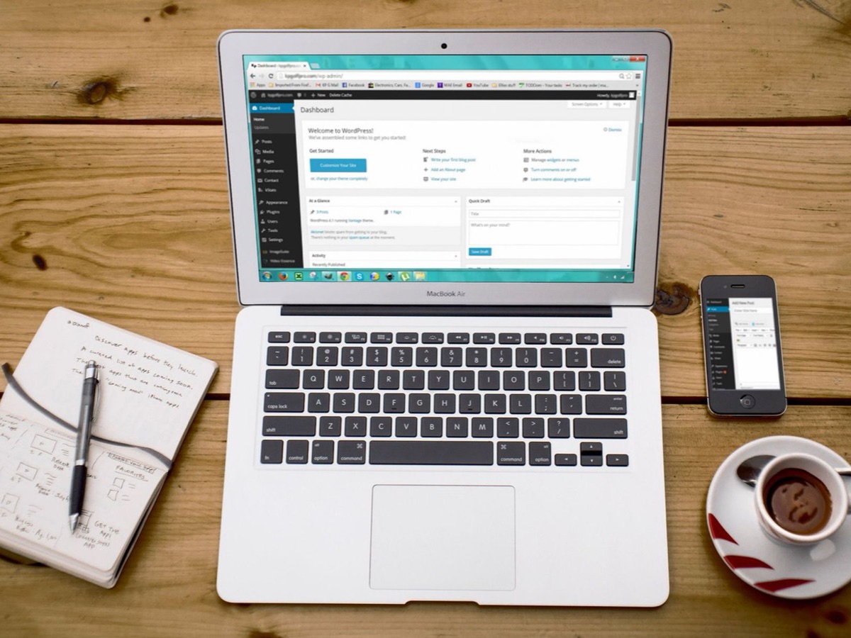 Tableau de bord WordPress sur ordinateur portable avec carnet et café, poste de travail d'un consultant SEO WordPress