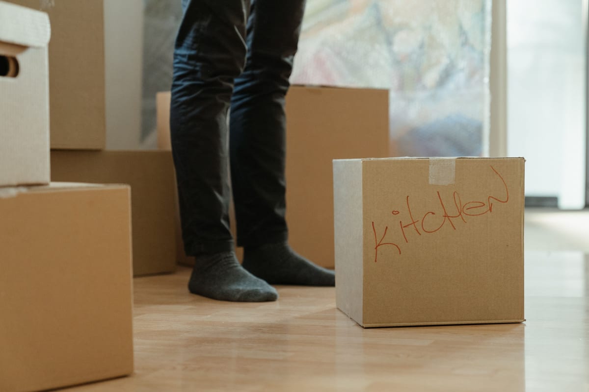 Cartons de déménagement étiquetés dans un logement vide, image d'une migration de site préparée