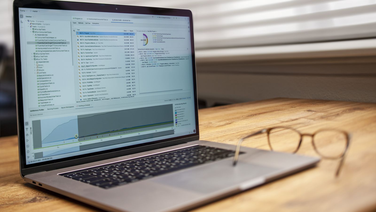 Logiciel d'analyse affichant une liste de métriques hiérarchisées sur un ordinateur portable posé sur un bureau en bois.