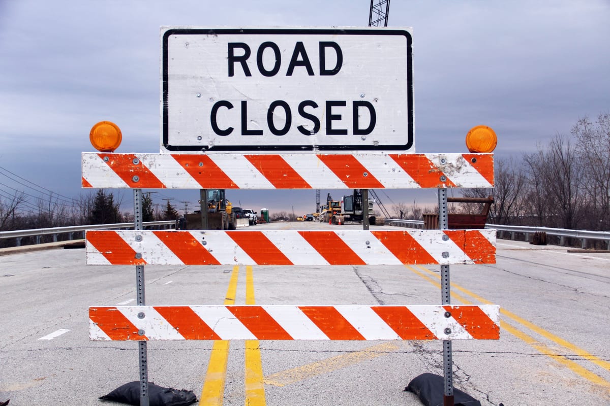 Barrière « road closed » en travers d'une route, image d'un site coupé du trafic par une pénalité Google