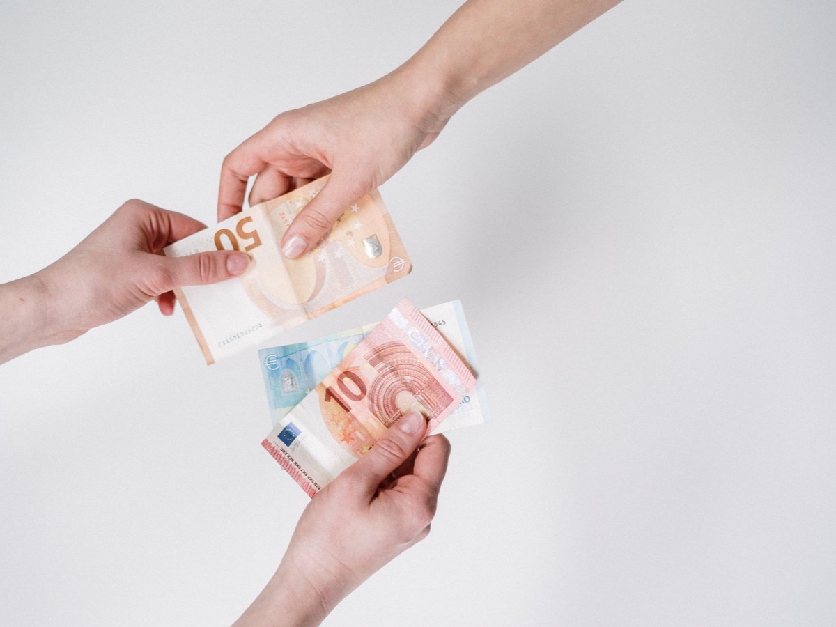 Mains échangeant des billets en euros, quand le référencement pas cher finit par coûter plus cher