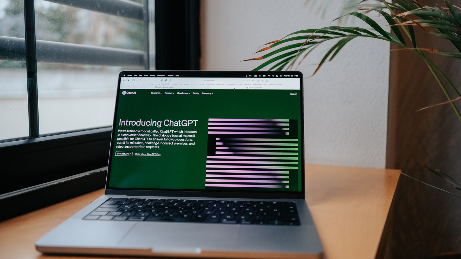Un ordinateur portable ouvert sur la page d'accueil de ChatGPT, posé sur un bureau lumineux près d'une fenêtre.