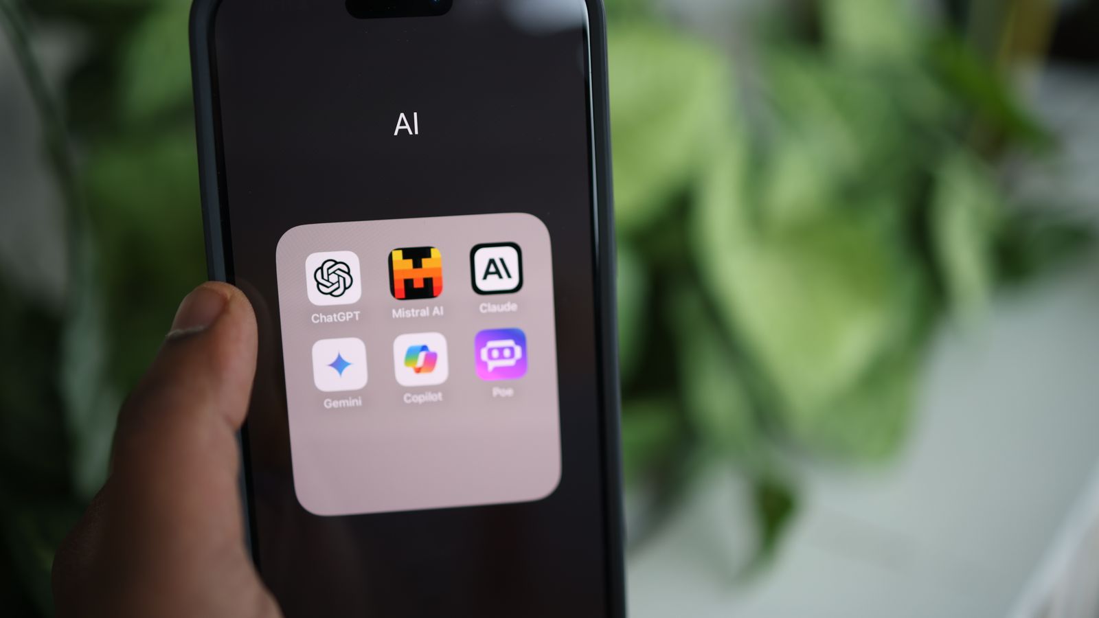 Un dossier d'applications d'IA (ChatGPT, Claude, Gemini, Mistral, Copilot) ouvert sur l'écran d'un smartphone tenu en main.